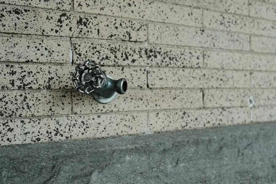 Faucet on a brick wall.