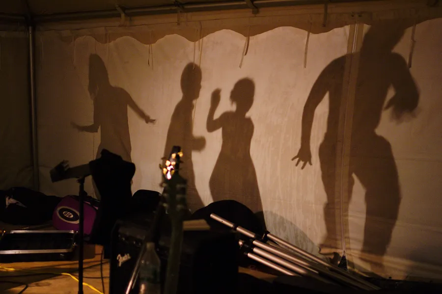 Silhouettes dancing behind the tent at a Duke Baxter wedding gig.